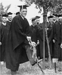 A Male Graduate Uses a Spade to Plant a Tree