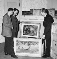 Fred Shane, Elmer Ellis, and Douglas Hansen look at paintings from the Scruggs - Vandervoort - Barney 'Missouri - Heart of the Nation' Collection. The upper painting is Shane's 'The Old Cemetery'; the lower is Howard Baer's 'Floatin' Fishing'.